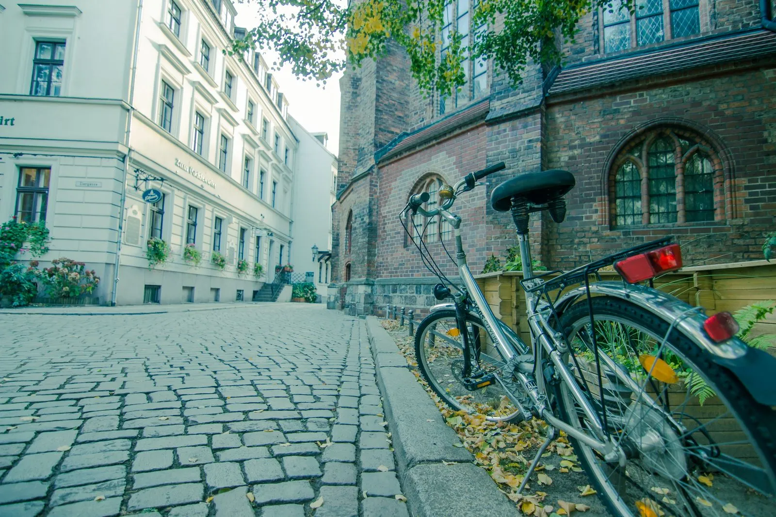 A bicycle leans against a historic building on a cobblestone street in Berlin.